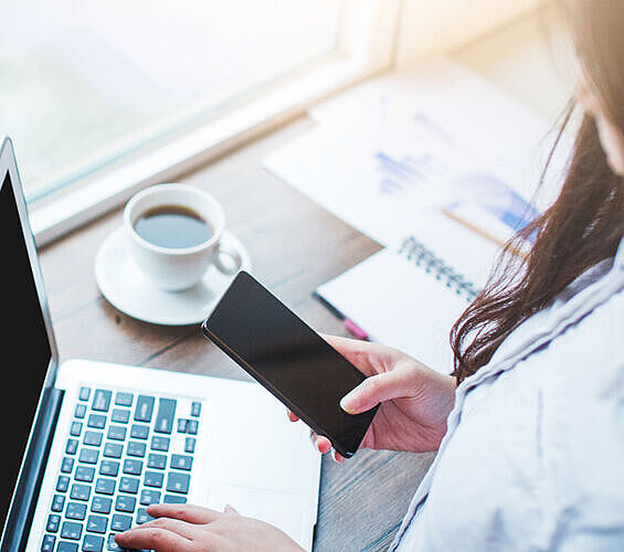 Frau mit Laptop und Smartphone